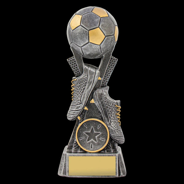A soccer-themed trophy featuring a soccer ball on top of crossed soccer cleats, with a circular star medallion and a blank rectangular plaque on a pedestal, shown against a plain white background.