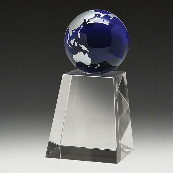 Blue glass globe on a clear pedestal against a dark background