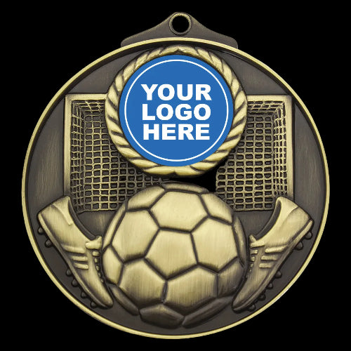 A customizable round soccer medal with a gold and bronze finish, featuring a soccer ball, cleats, and net design. A blue circular badge at the top center contains the placeholder text 'YOUR LOGO HERE'.