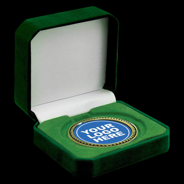 A green velvet presentation box shown open on a white background, with a round blue-and-gold custom logo medallion displayed in the center.