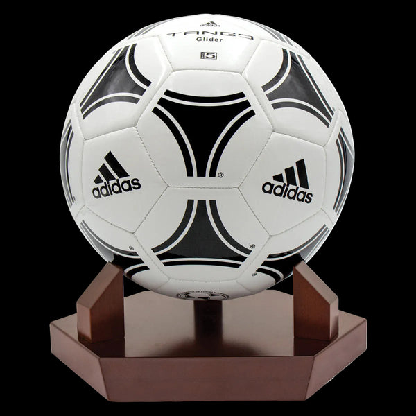 White and black Adidas soccer ball on a wooden stand with a white background